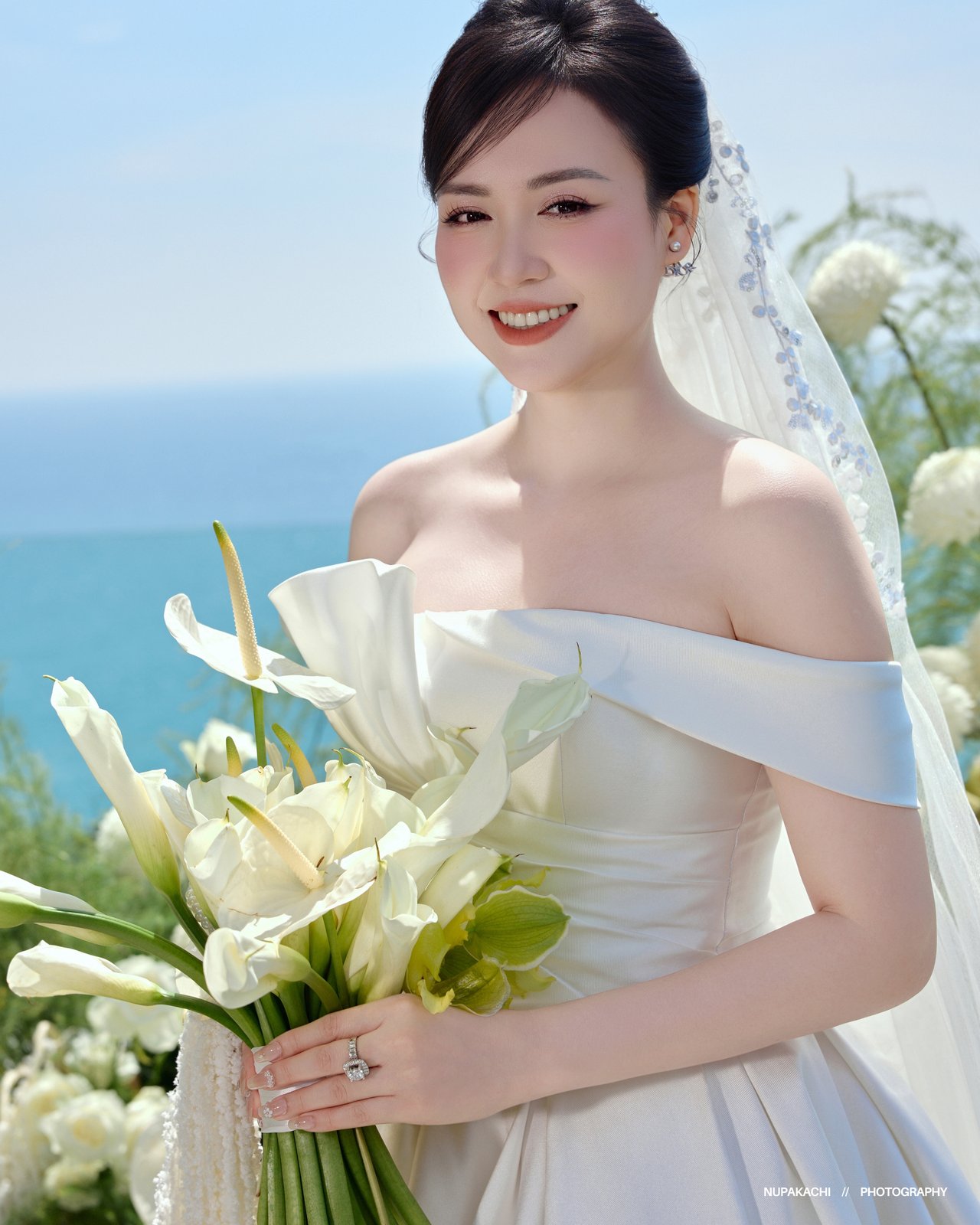 Cô dâu với hoa trắng bên vách biển